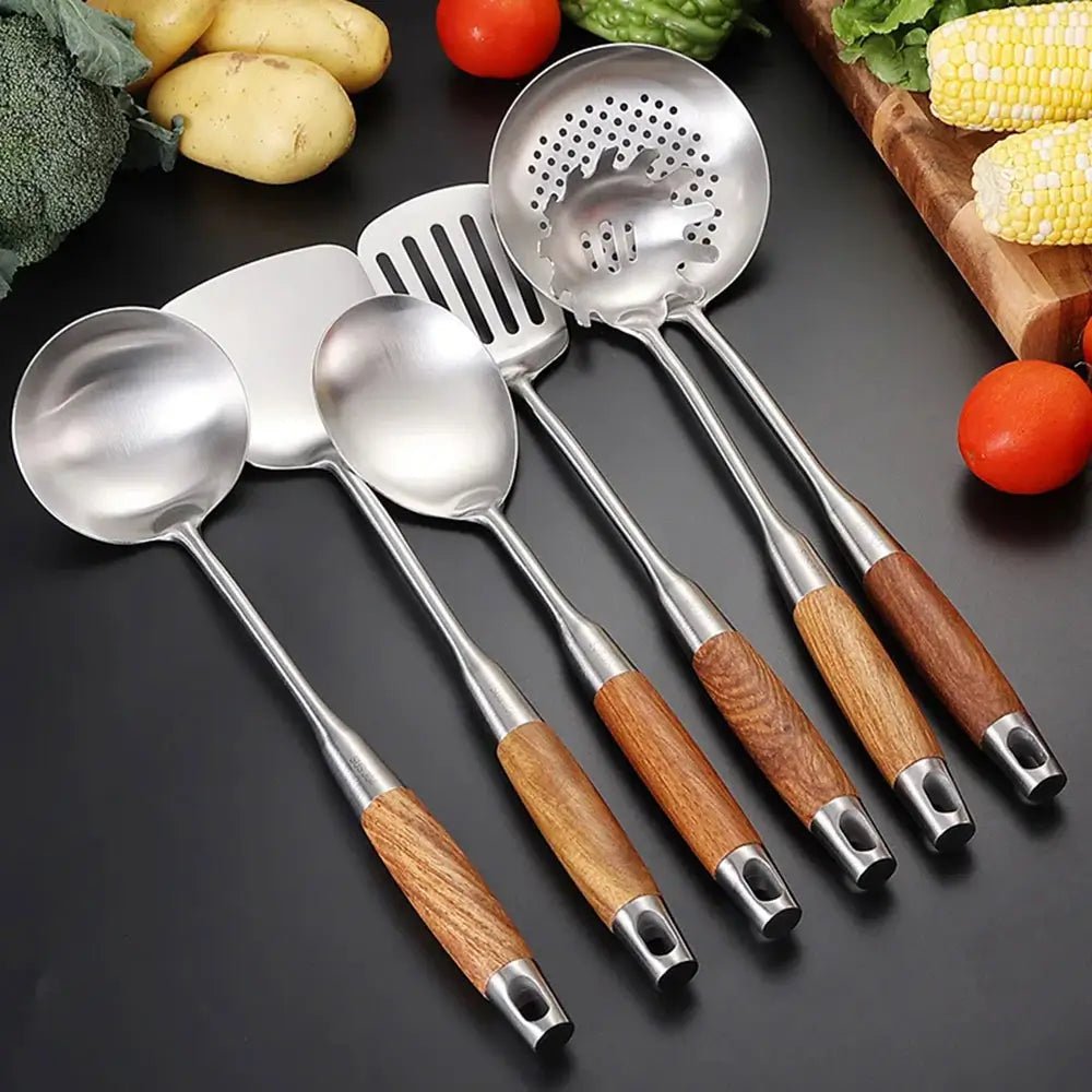 Stainless steel cooking utensils with wooden handles, including ladle, spatula, slotted spoon, and pasta server.