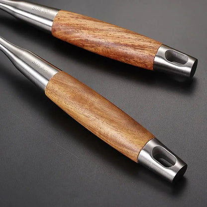 Close-up of wooden handles on stainless steel cooking utensils, showing smooth grip design and durable metal ends for everyday kitchen use.