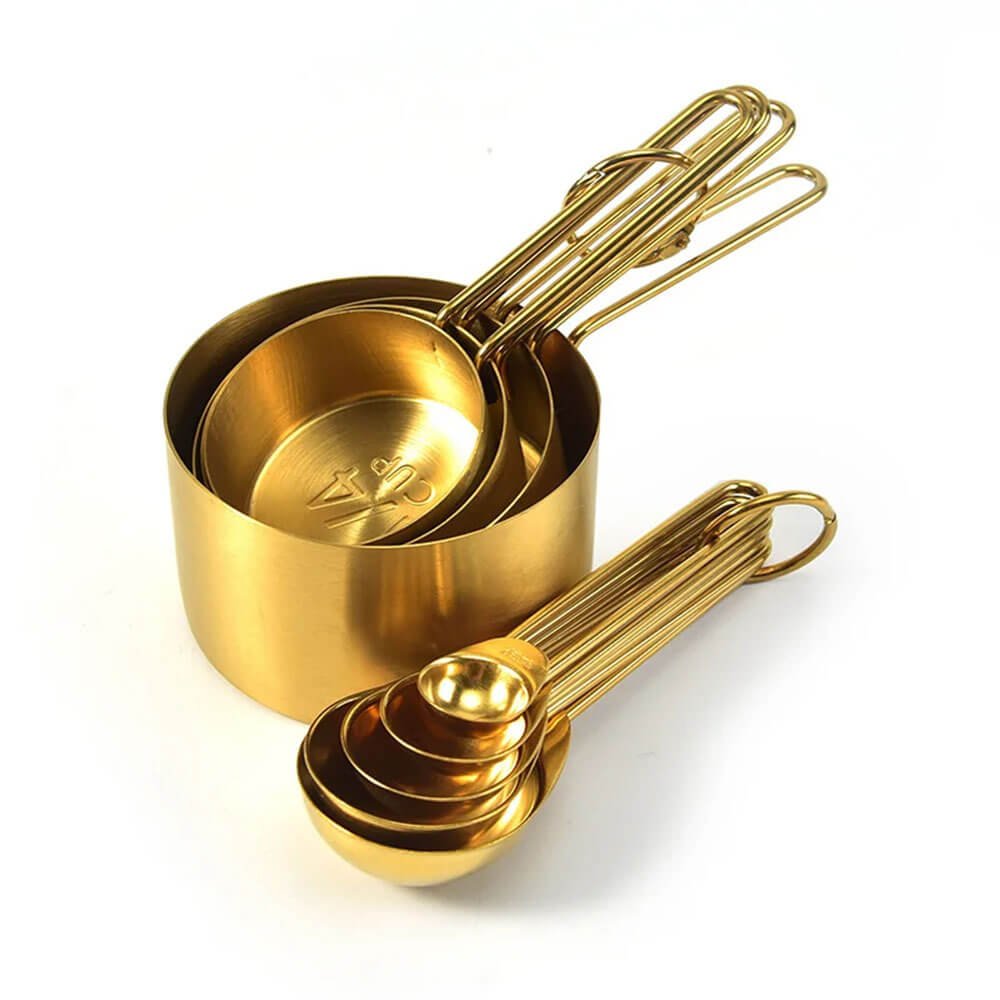 A sleek and elegant stainless steel measuring cups and spoons set with a luxurious gold finish displayed on a white background. The cups are neatly nested together, showcasing their space-saving design, while the spoons are stacked for easy organization. This set is perfect for precise measurements and adds a touch of sophistication to any kitchen.