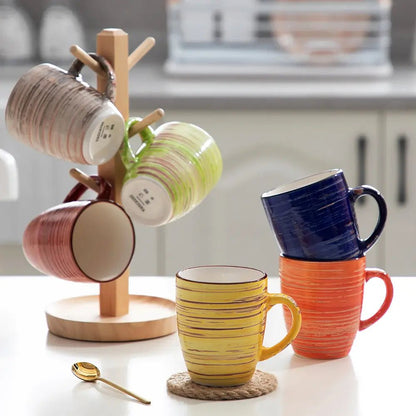 Colorful mugs on a wooden stand and countertop with a blurred kitchen background