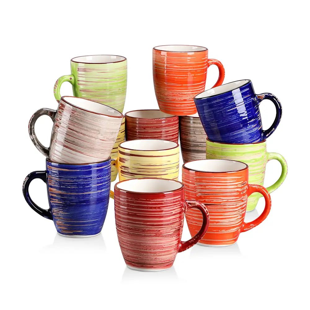 Colorful stoneware coffee mugs with ribbed textured glaze in red, blue, green, yellow, orange, and beige stacked on white background.