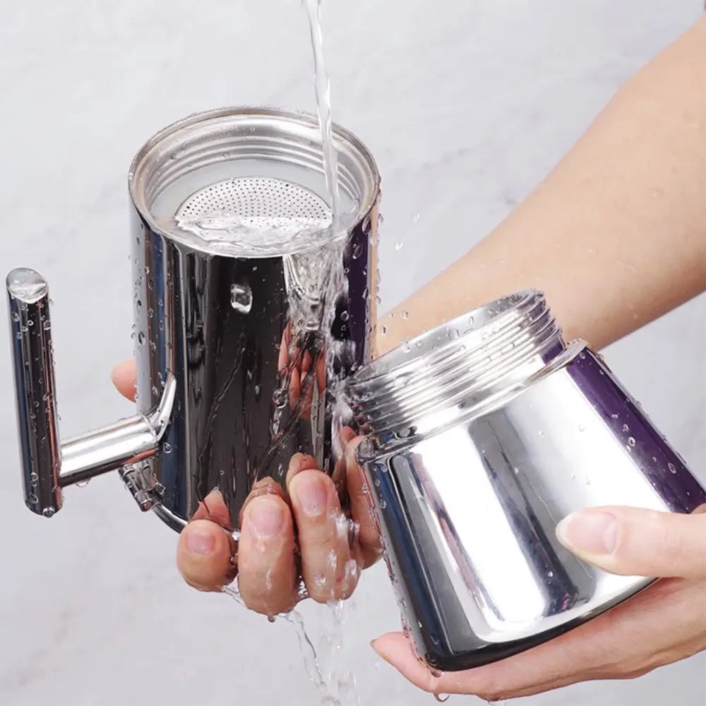 Hands rinsing stainless steel stovetop espresso maker under running water, showing easy cleaning of top and bottom parts.