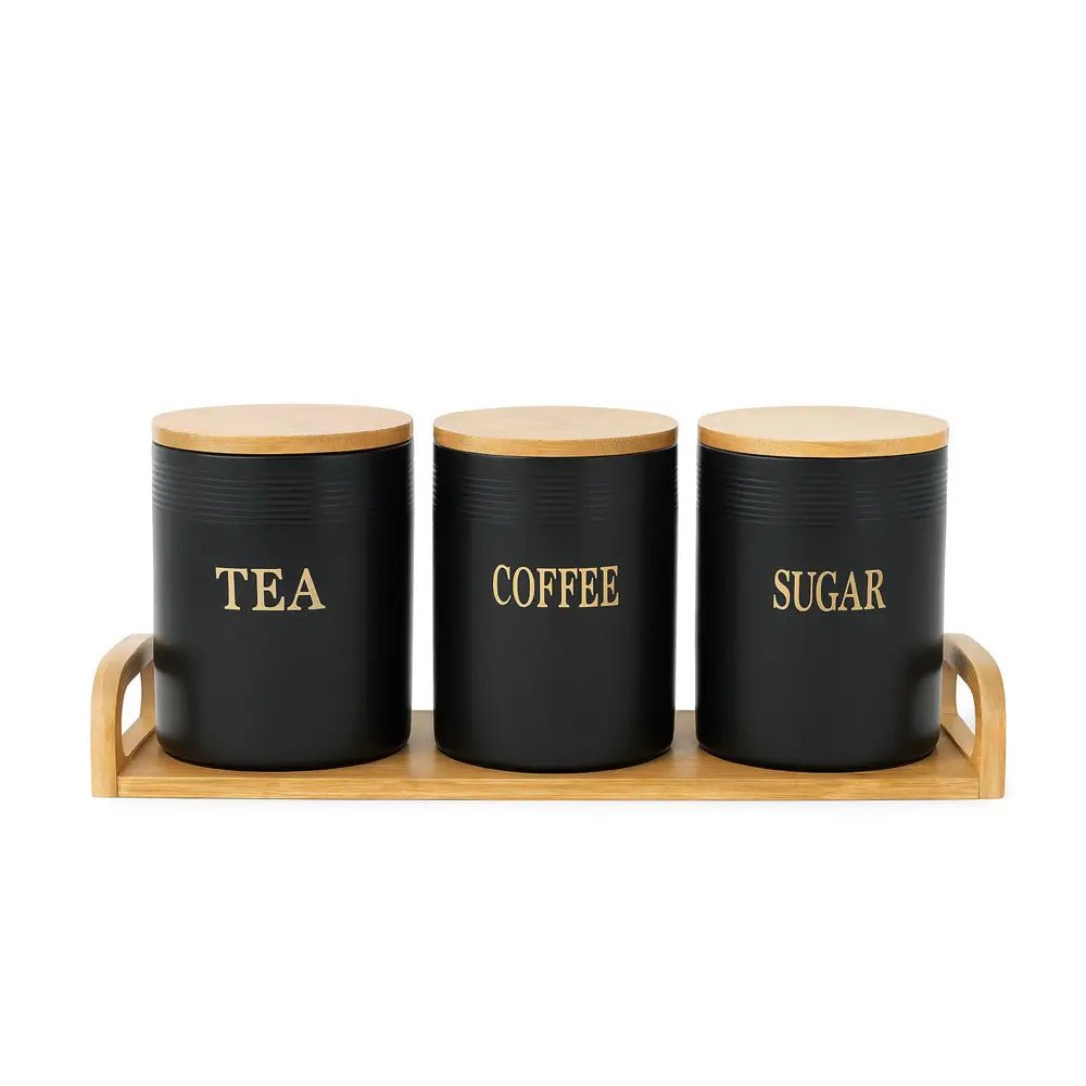 Tea coffee sugar canisters in matte black with bamboo lids, arranged on a wooden tray against a white background.