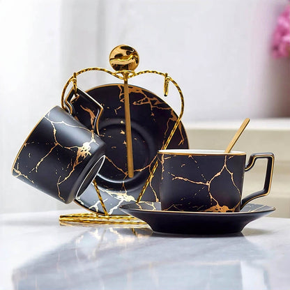 A luxurious collection of tea cups and saucers in bulk, featuring a glossy black finish with gold veining, complemented by a golden stand for a sophisticated presentation. Perfect for upscale gatherings or elegant gifting.