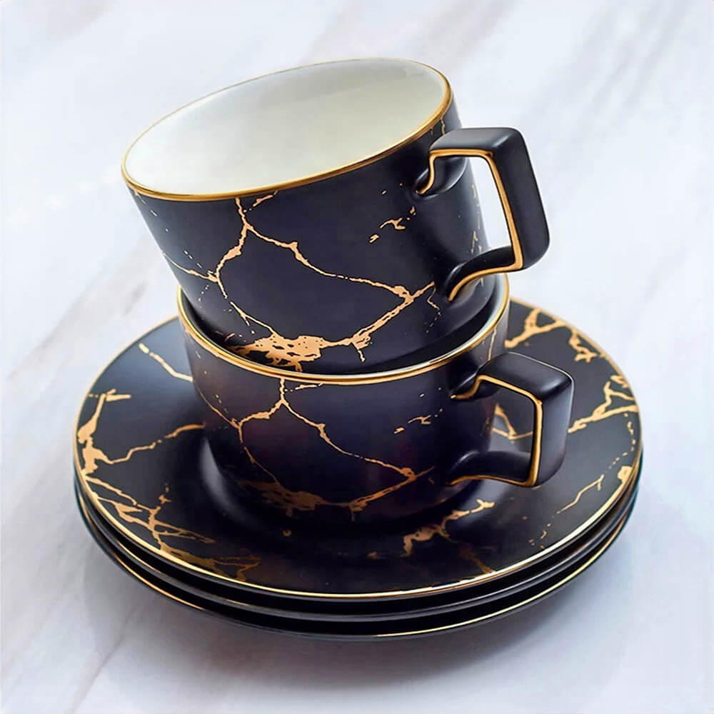 A stunning tea cups and saucers set featuring a glossy black finish with intricate gold veining, designed to add sophistication and elegance to any tea experience.