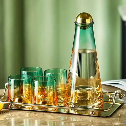 Glass water carafe and glass set on a gold tray, featuring a green and amber gradient carafe with a gold ball lid and four matching glasses.