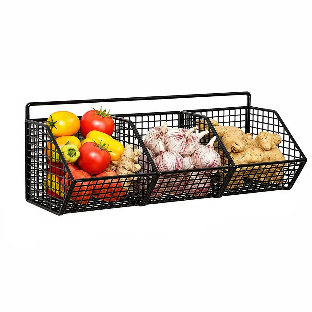 Wire basket kitchen storage with three wall-mounted compartments holding vegetables, garlic, and ginger root.