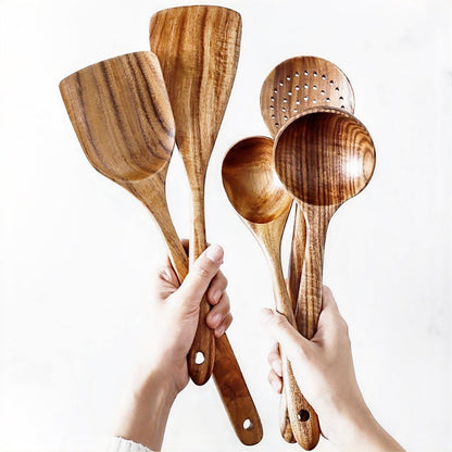 A woman holding 5 pieces from a wood cooking utensils set showcasing durable and stylish kitchen tools.