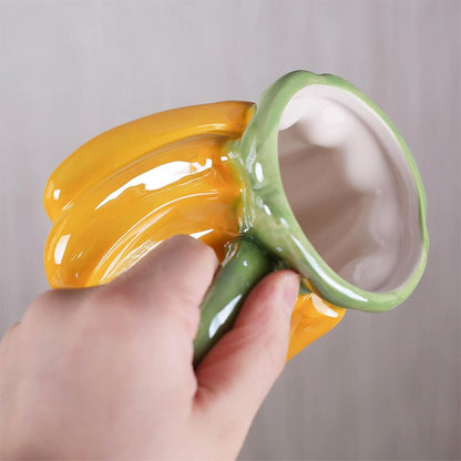 A woman holding a yellow banana-shaped mug with a detailed design and ergonomic handle.